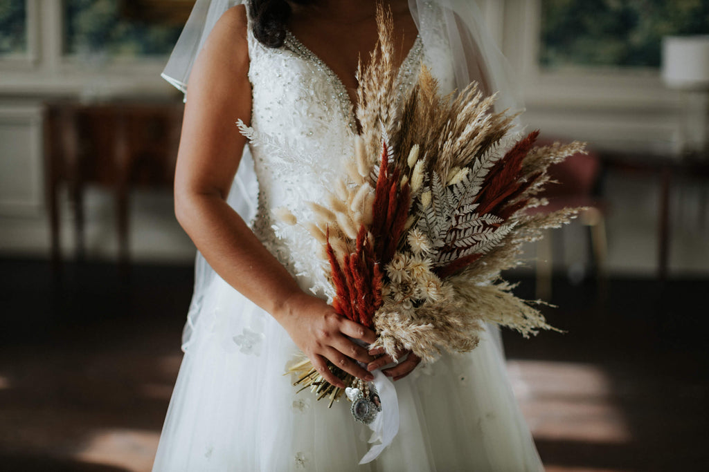 Bride holds Hidden Botanics dried wildflower wedding bouquet.